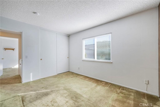 unfurnished bedroom with a textured ceiling, a closet, and carpet flooring