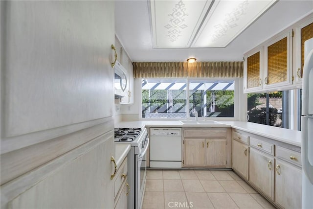 kitchen featuring sink, white appliances, and light tile patterned flooring