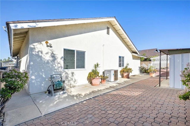 rear view of property with a patio area and central air condition unit