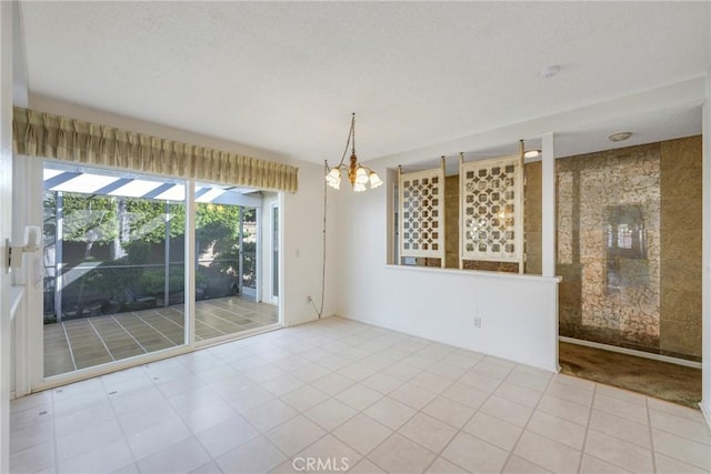 tiled empty room featuring a chandelier