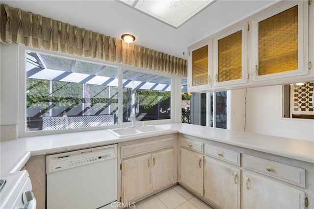 kitchen with stove, light tile patterned flooring, light brown cabinetry, dishwasher, and sink