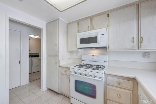 kitchen featuring light tile patterned floors, light brown cabinetry, independent washer and dryer, and white appliances