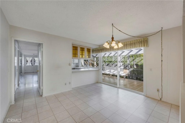 unfurnished dining area with light tile patterned floors, a notable chandelier, and a textured ceiling