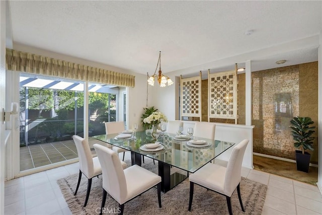 tiled dining room featuring an inviting chandelier