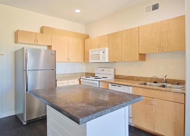 kitchen with light brown cabinetry, sink, dark hardwood / wood-style floors, a kitchen island, and white appliances