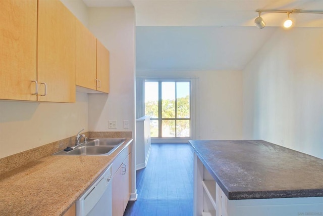 kitchen featuring light brown cabinetry, dishwasher, lofted ceiling, sink, and rail lighting