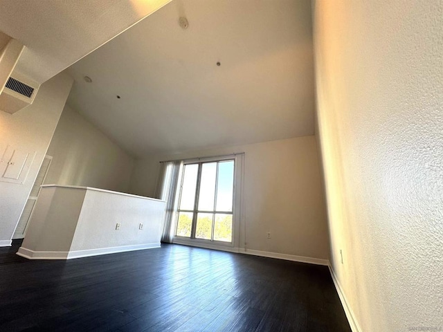 interior space with vaulted ceiling and dark hardwood / wood-style floors