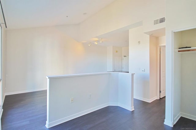 unfurnished room with dark hardwood / wood-style flooring and vaulted ceiling