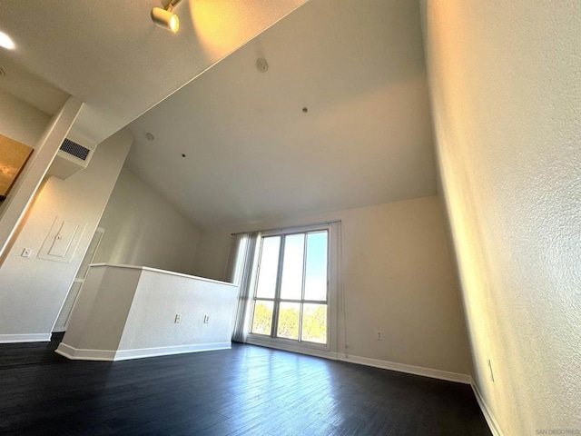 interior space with dark hardwood / wood-style floors and vaulted ceiling