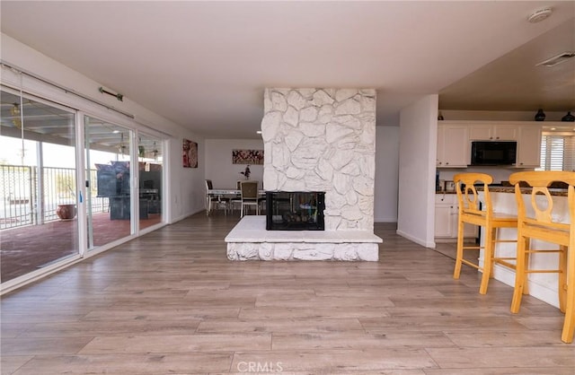 living room with light wood-type flooring and a fireplace