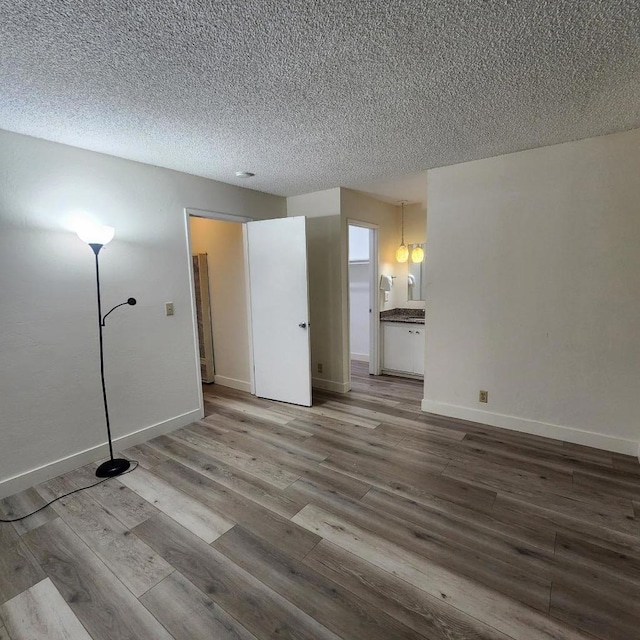 spare room featuring wood-type flooring and a textured ceiling