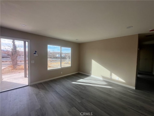 unfurnished living room with dark hardwood / wood-style flooring and plenty of natural light