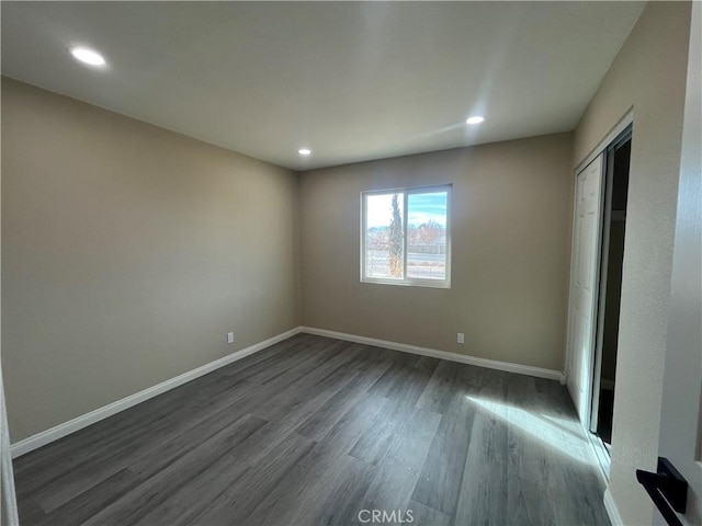 unfurnished bedroom with dark wood-type flooring and a closet