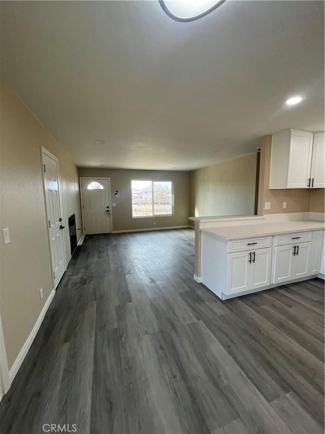 interior space with white cabinetry, dark hardwood / wood-style flooring, and kitchen peninsula