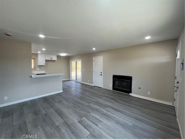 unfurnished living room with dark wood-type flooring