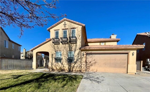 mediterranean / spanish home featuring a front lawn, a balcony, and a garage