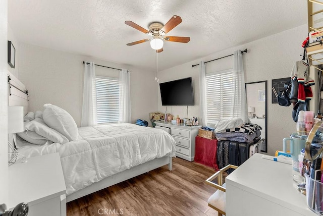 bedroom with a textured ceiling, ceiling fan, and hardwood / wood-style flooring