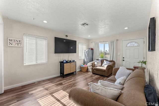 living room featuring a textured ceiling and hardwood / wood-style floors