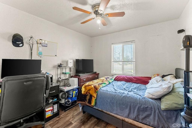 bedroom with a textured ceiling, ceiling fan, and dark hardwood / wood-style floors