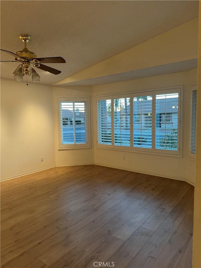 empty room featuring ceiling fan, lofted ceiling, and hardwood / wood-style flooring