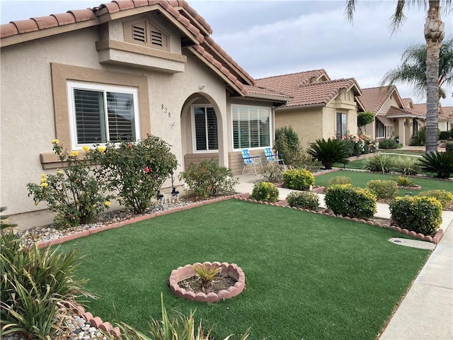 mediterranean / spanish home featuring a front yard