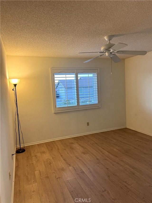 spare room with a textured ceiling, ceiling fan, and hardwood / wood-style floors