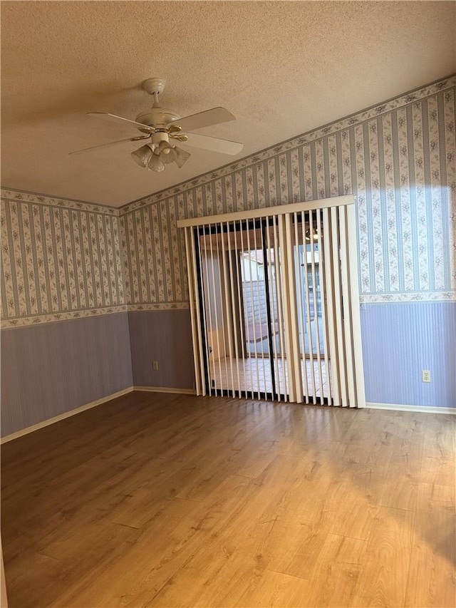 unfurnished room featuring a textured ceiling, ceiling fan, and wood-type flooring