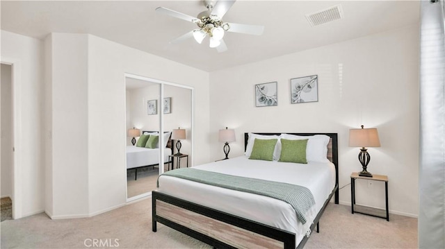 bedroom with ceiling fan, a closet, and light carpet