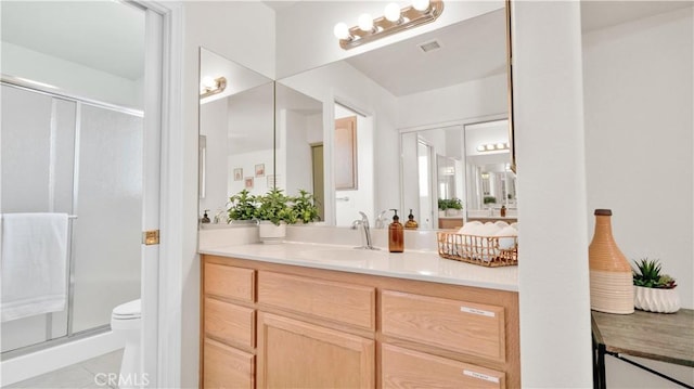 bathroom with an enclosed shower, vanity, and toilet