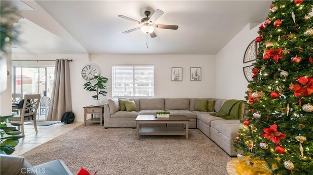 living room with ceiling fan, vaulted ceiling, and light tile patterned flooring