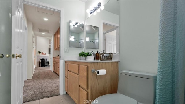 bathroom with toilet, vanity, and tile patterned flooring