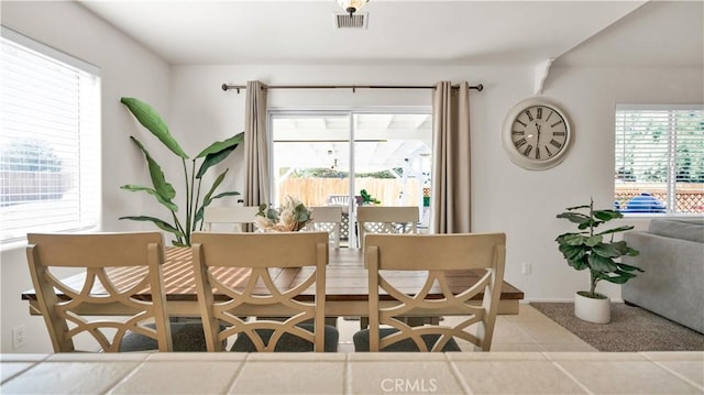 tiled dining space with a wealth of natural light