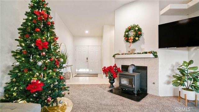 carpeted living room with a wood stove