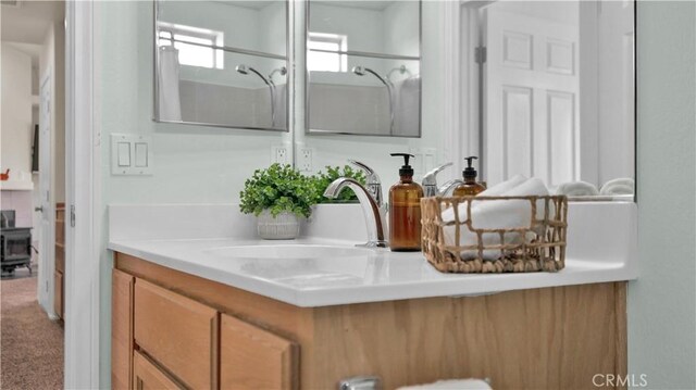 bathroom featuring a shower and vanity