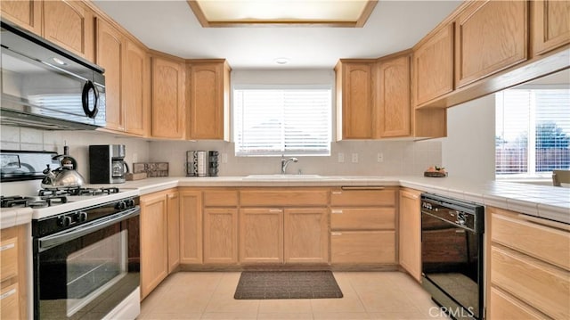 kitchen with black appliances, decorative backsplash, sink, light brown cabinetry, and light tile patterned floors