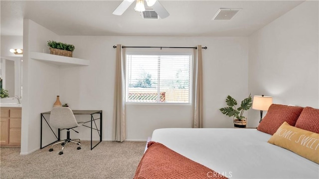 bedroom with ceiling fan, light colored carpet, ensuite bathroom, and sink