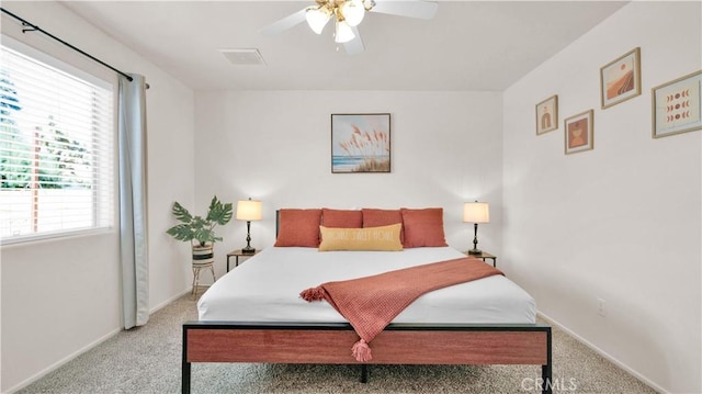 carpeted bedroom featuring ceiling fan and multiple windows