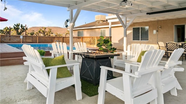 view of patio with a mountain view, a fenced in pool, and a fire pit