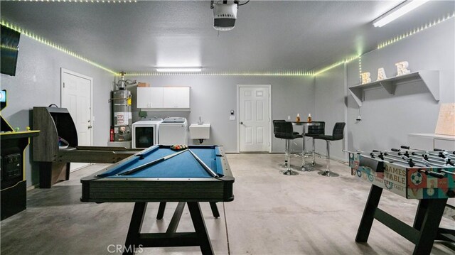 playroom featuring billiards, sink, independent washer and dryer, and strapped water heater