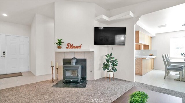 living room featuring light tile patterned floors and a wood stove