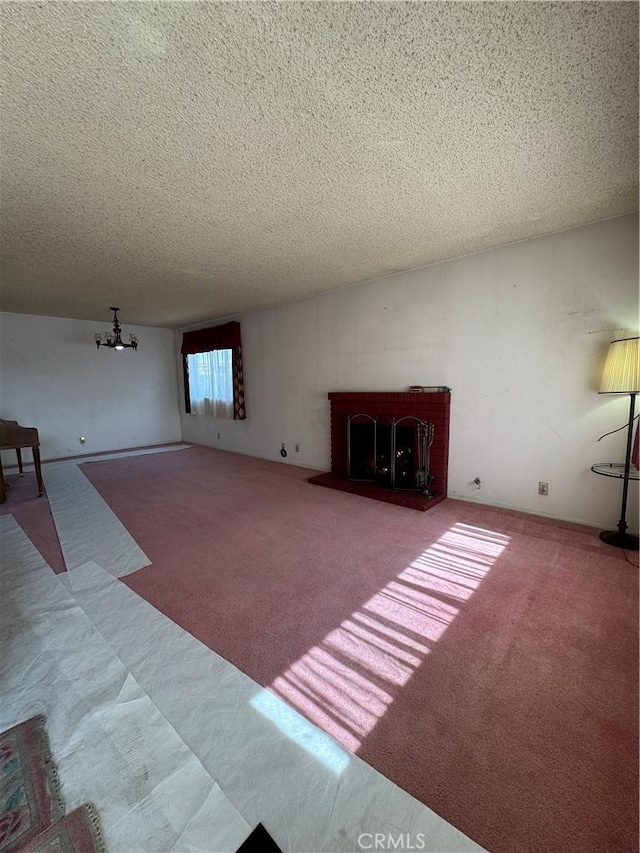 unfurnished living room with a chandelier, carpet floors, and a textured ceiling