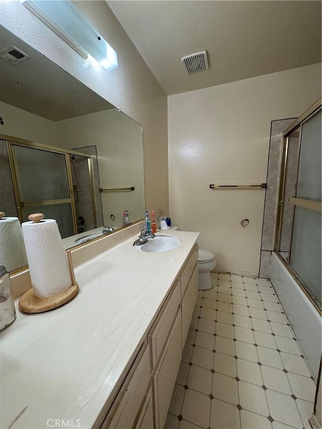 full bathroom featuring toilet, vanity, and combined bath / shower with glass door