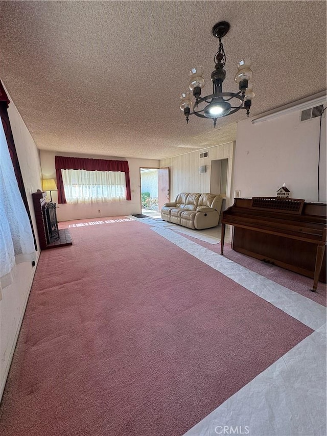 interior space featuring carpet floors, a textured ceiling, and a notable chandelier