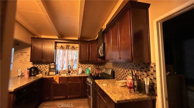 kitchen with backsplash, sink, dark brown cabinetry, light stone countertops, and stainless steel appliances