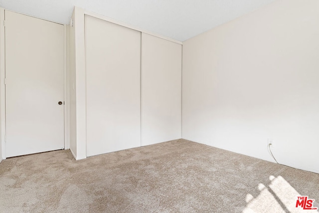 spare room featuring light carpet