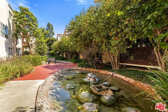 view of home's community featuring a patio area and a small pond