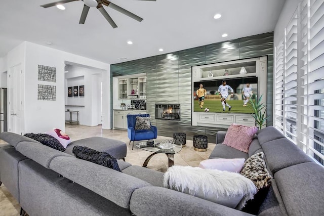 living room with ceiling fan, built in features, and a tile fireplace