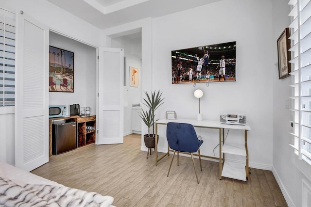 office area featuring light hardwood / wood-style flooring and bar