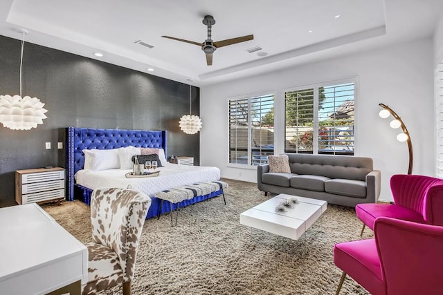 bedroom with ceiling fan and a tray ceiling