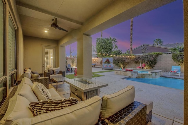 patio terrace at dusk featuring ceiling fan, a swimming pool with hot tub, and outdoor lounge area